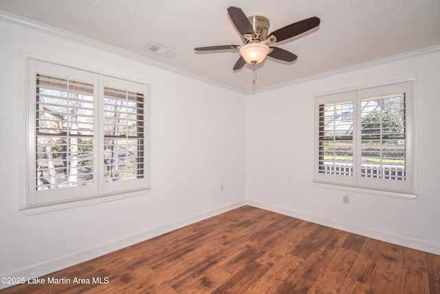 unfurnished room with a textured ceiling, visible vents, baseboards, dark wood-style floors, and crown molding