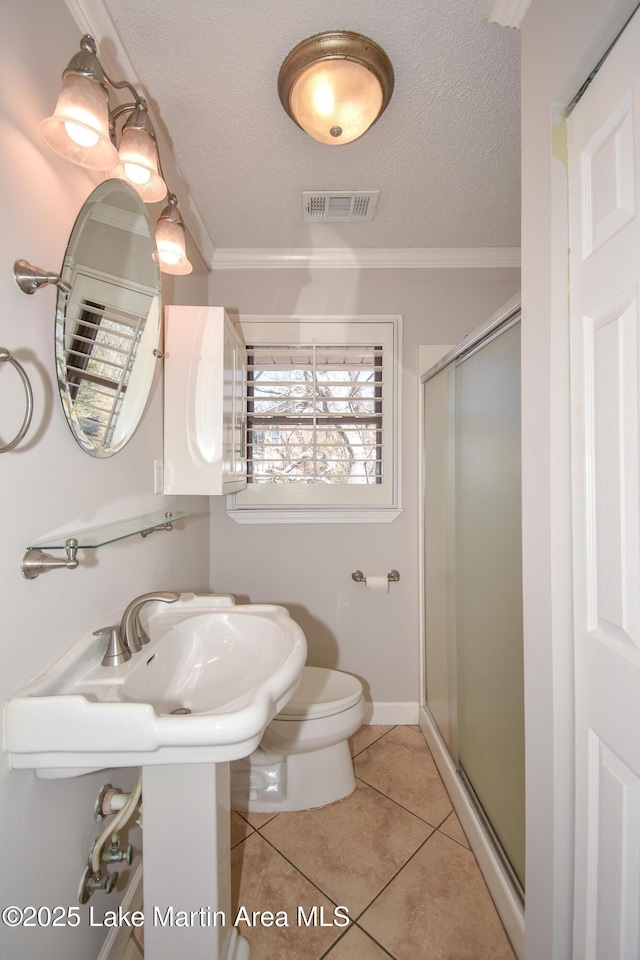 full bathroom featuring visible vents, ornamental molding, a shower stall, a textured ceiling, and tile patterned floors