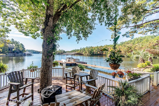 wooden deck with a water view, a floating dock, and grilling area