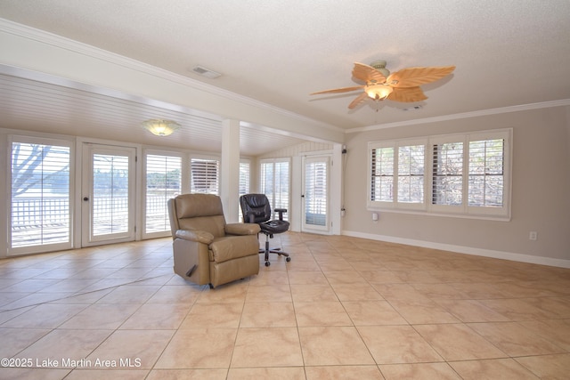 living area with crown molding, light tile patterned floors, visible vents, ceiling fan, and baseboards