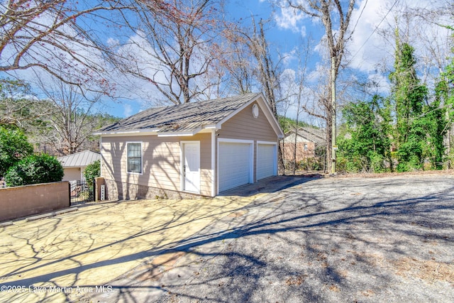 detached garage featuring fence and a gate