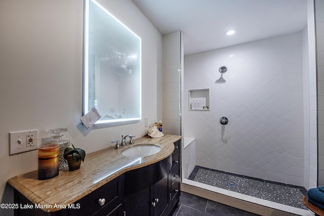 full bath featuring recessed lighting, walk in shower, vanity, and tile patterned flooring