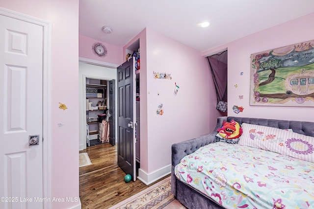 bedroom with baseboards and wood finished floors