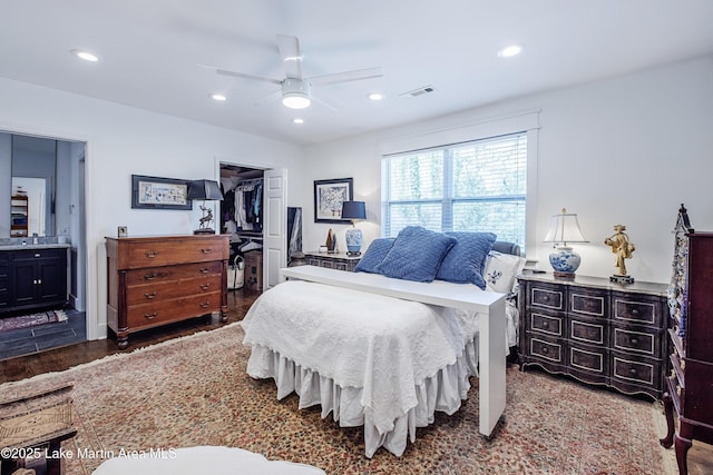 bedroom featuring visible vents, a ceiling fan, ensuite bath, wood finished floors, and recessed lighting