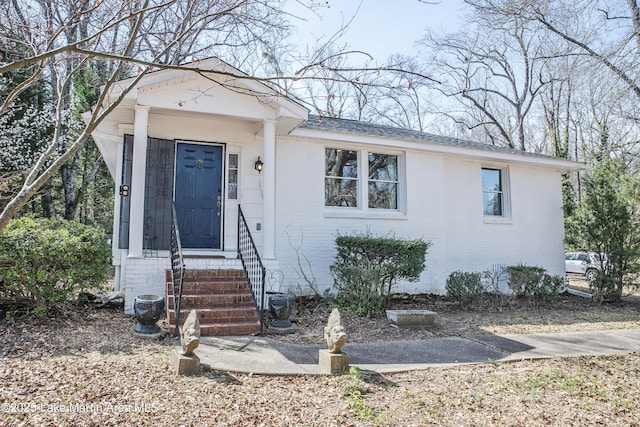 view of front facade with brick siding and entry steps