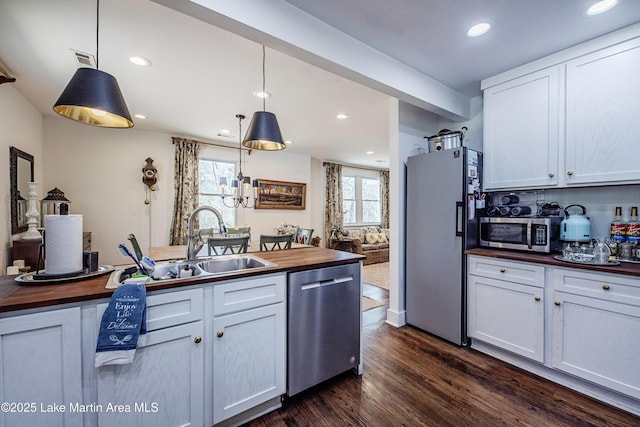 kitchen with dark wood finished floors, butcher block counters, white cabinetry, and stainless steel appliances