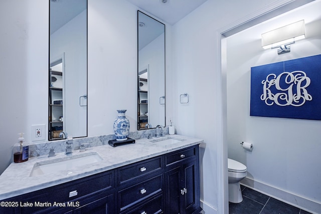 bathroom featuring a sink, toilet, double vanity, and tile patterned flooring