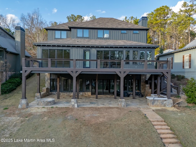 rear view of property with a wooden deck, a yard, and a patio area