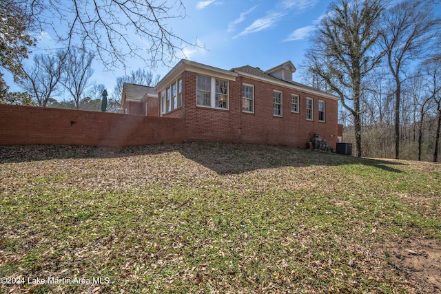 view of home's exterior with central AC unit and a lawn