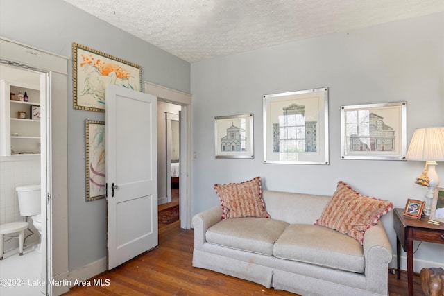 living area with hardwood / wood-style flooring and a textured ceiling