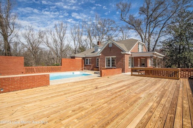 deck featuring a fenced in pool