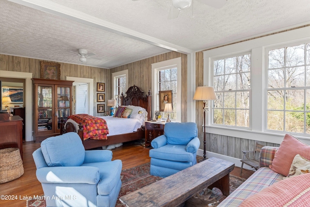 bedroom featuring wood-type flooring, ceiling fan, and a textured ceiling