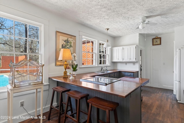 kitchen featuring white cabinets, a kitchen breakfast bar, and kitchen peninsula