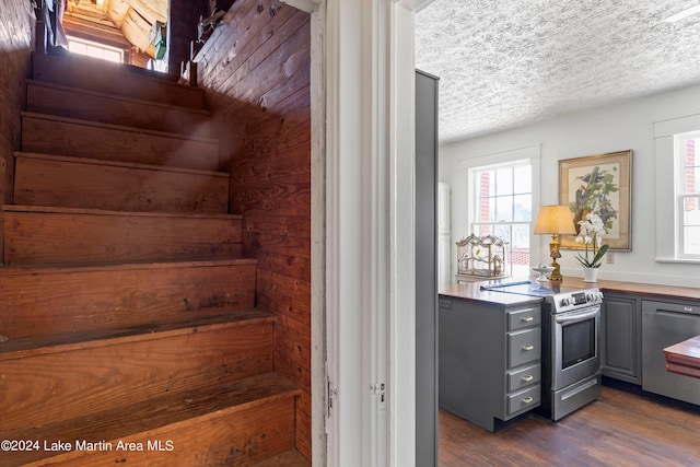 stairs featuring hardwood / wood-style flooring and a textured ceiling