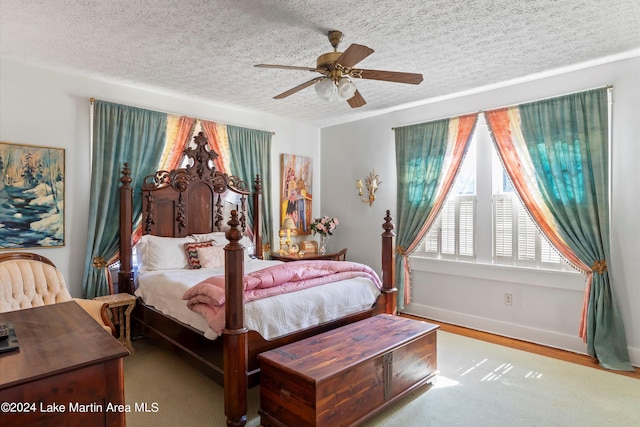 bedroom with ceiling fan, a textured ceiling, and light wood-type flooring