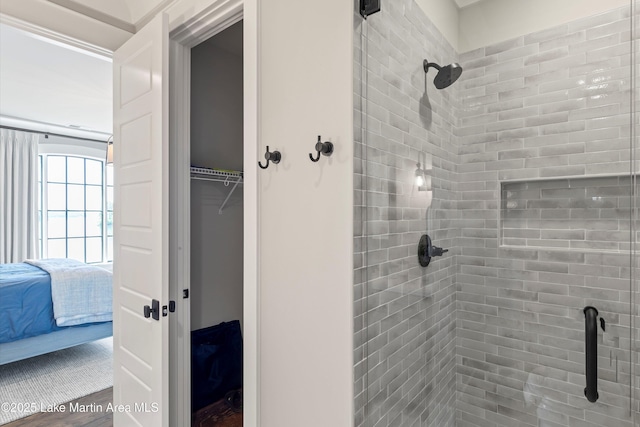 bathroom featuring hardwood / wood-style floors and a tile shower