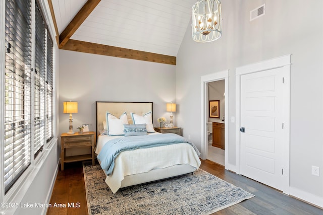 bedroom with dark hardwood / wood-style flooring, beam ceiling, high vaulted ceiling, a notable chandelier, and connected bathroom