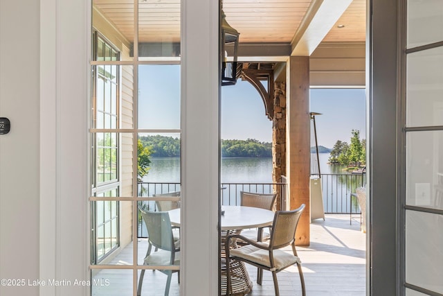 doorway to outside with a water view, wood ceiling, and wood-type flooring