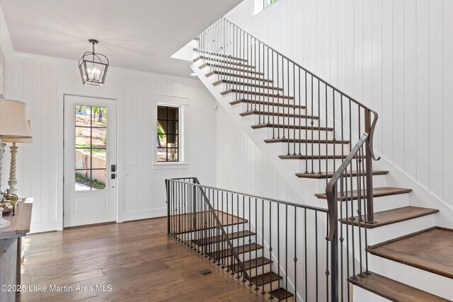 foyer entrance with dark hardwood / wood-style floors and a chandelier