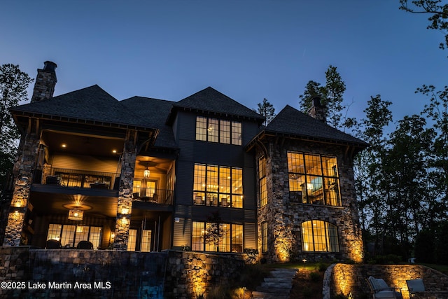 back house at dusk with a balcony