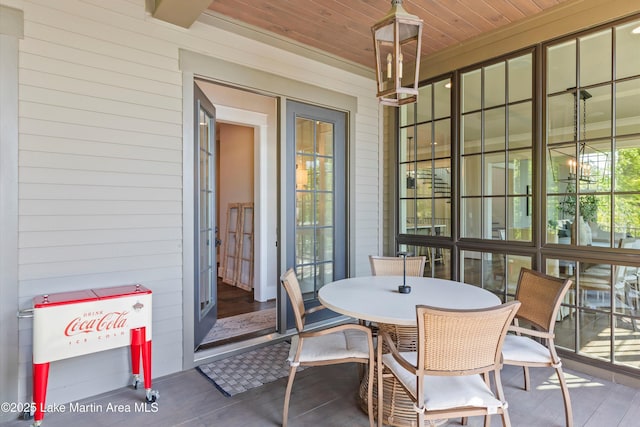 sunroom / solarium featuring wooden ceiling and a chandelier