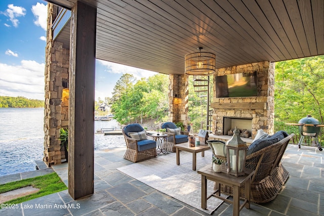 view of patio featuring an outdoor living space with a fireplace and a water view