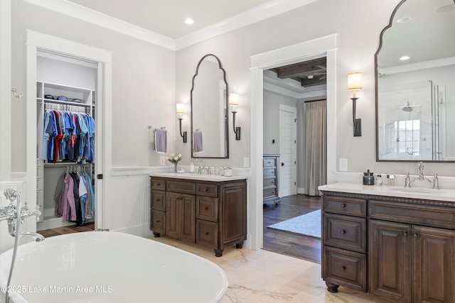 bathroom with vanity, a tub to relax in, and crown molding