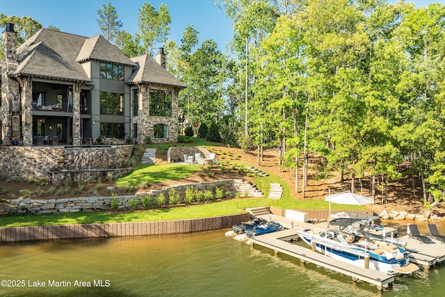 rear view of property featuring a water view and a balcony