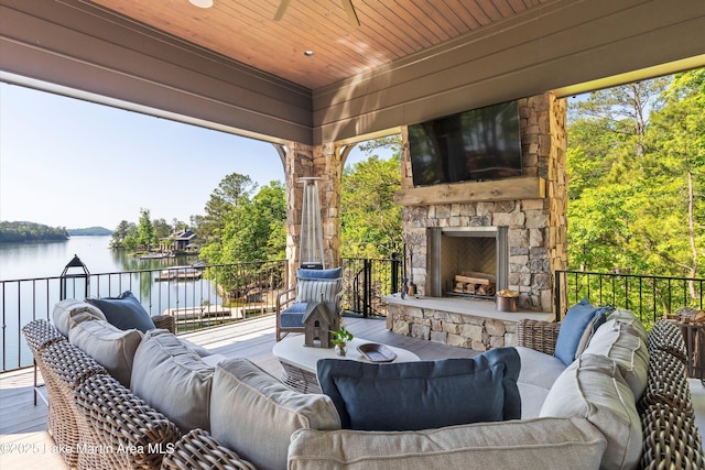 view of patio / terrace with an outdoor living space with a fireplace and a water view