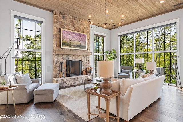 living room featuring a notable chandelier, dark hardwood / wood-style floors, wood ceiling, and a fireplace