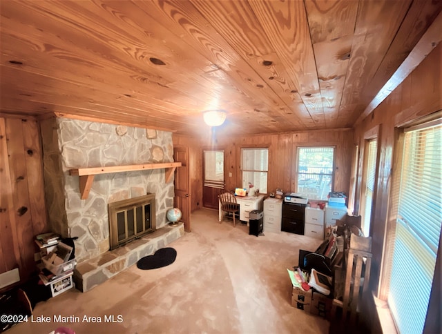 interior space with wood ceiling, a fireplace, wooden walls, and carpet floors