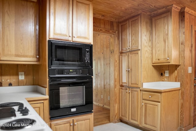 kitchen with wood ceiling, wooden walls, and black appliances