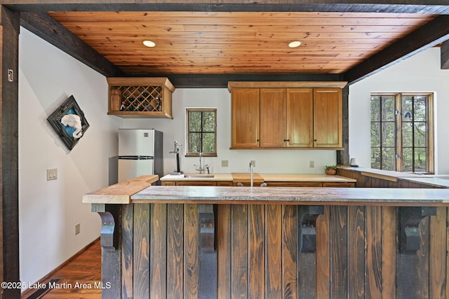 kitchen with dark wood-style floors, wooden ceiling, freestanding refrigerator, light countertops, and recessed lighting