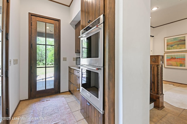 kitchen with stainless steel double oven, recessed lighting, light countertops, baseboards, and modern cabinets