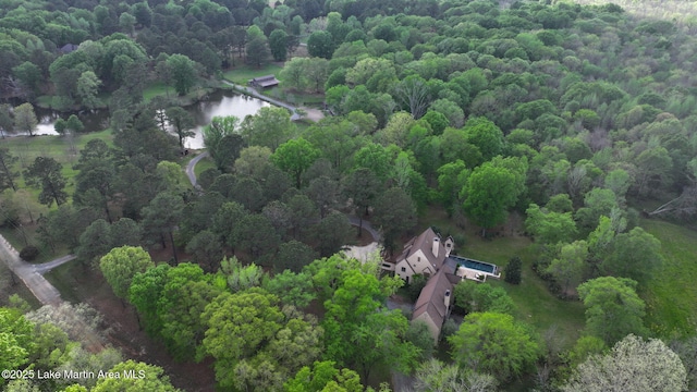 view of subject property featuring a nearby body of water and a forest