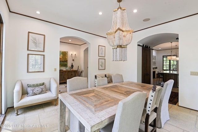dining area featuring a barn door, a chandelier, stone tile floors, arched walkways, and recessed lighting