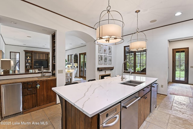 kitchen featuring a sink, open floor plan, arched walkways, and recessed lighting