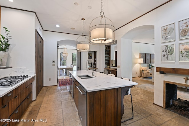kitchen featuring a sink, arched walkways, stone tile flooring, modern cabinets, and recessed lighting