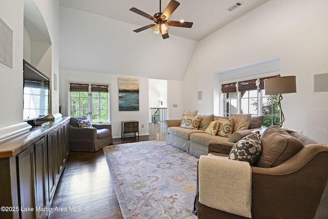 living area featuring dark wood-type flooring, a ceiling fan, and high vaulted ceiling