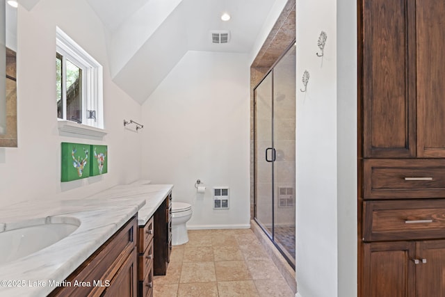 bathroom featuring a stall shower, toilet, vanity, and baseboards