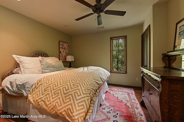 bedroom featuring dark wood finished floors, baseboards, and a ceiling fan