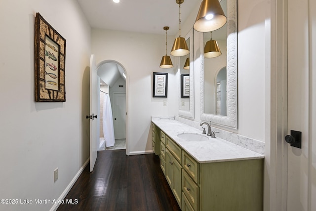 full bath with vanity, wood finished floors, and baseboards