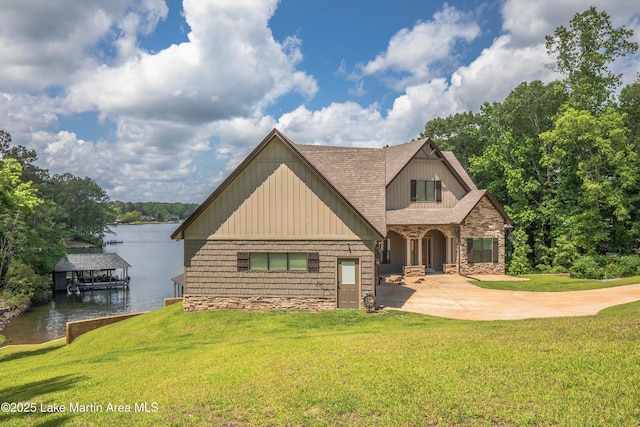 craftsman-style home with a water view and a front lawn