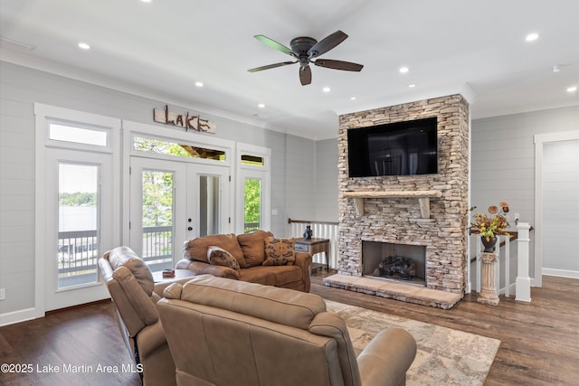 living room with a fireplace, dark wood-type flooring, and ceiling fan