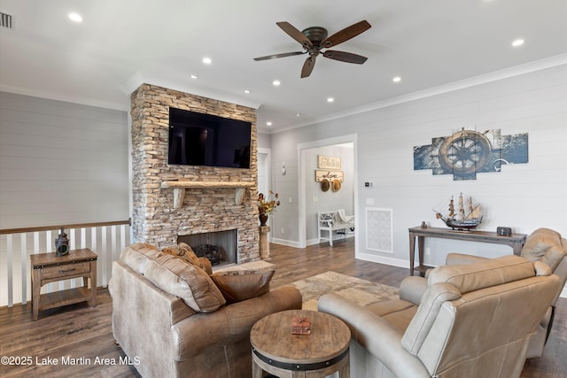 living room with ornamental molding, dark hardwood / wood-style floors, and a stone fireplace