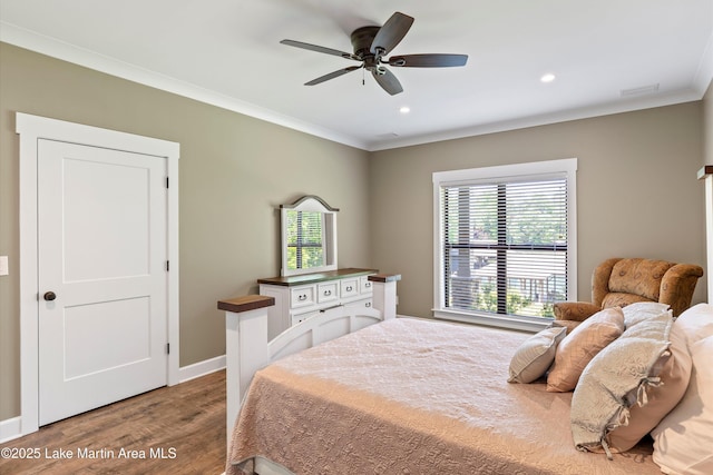 bedroom featuring hardwood / wood-style flooring, ornamental molding, and ceiling fan