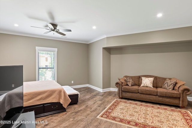 bedroom with ceiling fan, ornamental molding, and wood-type flooring