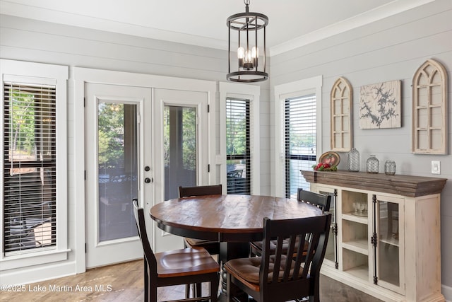 dining area featuring hardwood / wood-style floors, wooden walls, and french doors