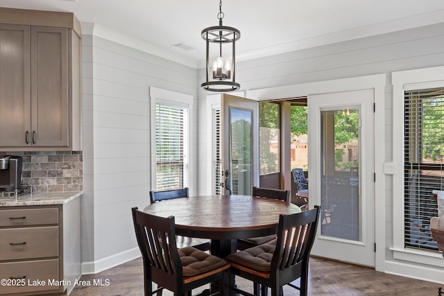 dining room featuring wooden walls, a wealth of natural light, and dark hardwood / wood-style flooring