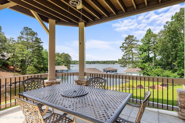 wooden deck with a water view and a lawn